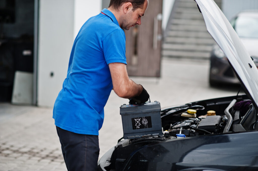 Monteur plaatst een nieuwe auto-accu tijdens een onderhoudsbeurt bij Dynamostartmotor.nl.
