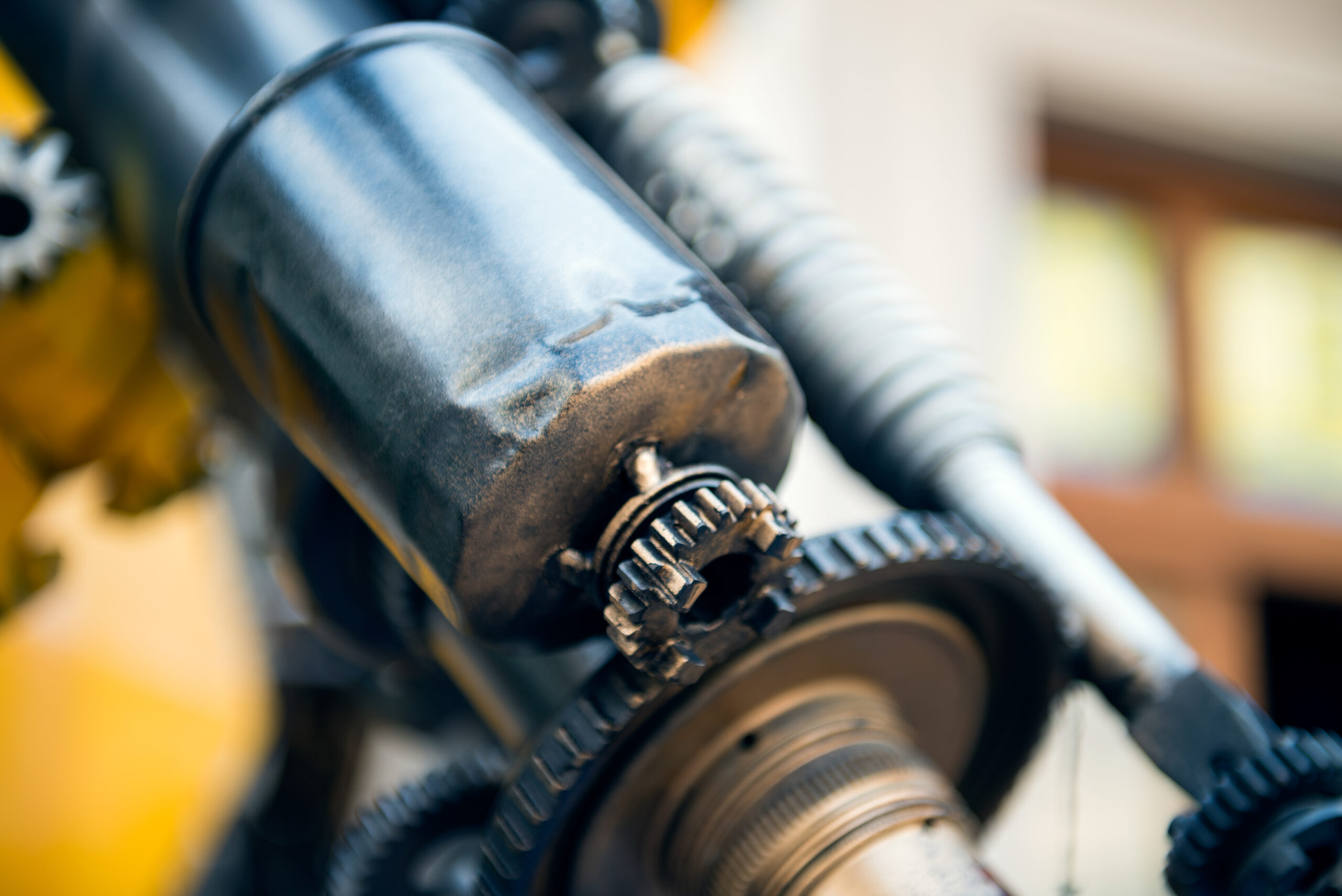 Close-up van een beschadigde startmotor met tandwiel, gereed voor revisie en reparatie bij Dynamostartmotor.nl.
