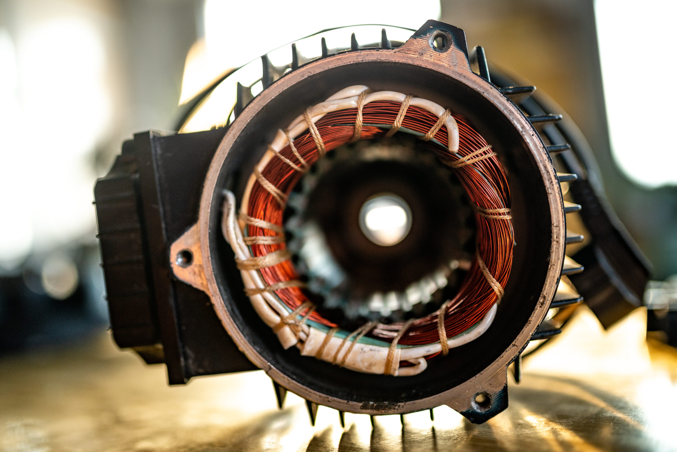 Close-up van een open dynamo met koperen wikkelingen, klaar voor revisie bij dynamostartmotor.nl.